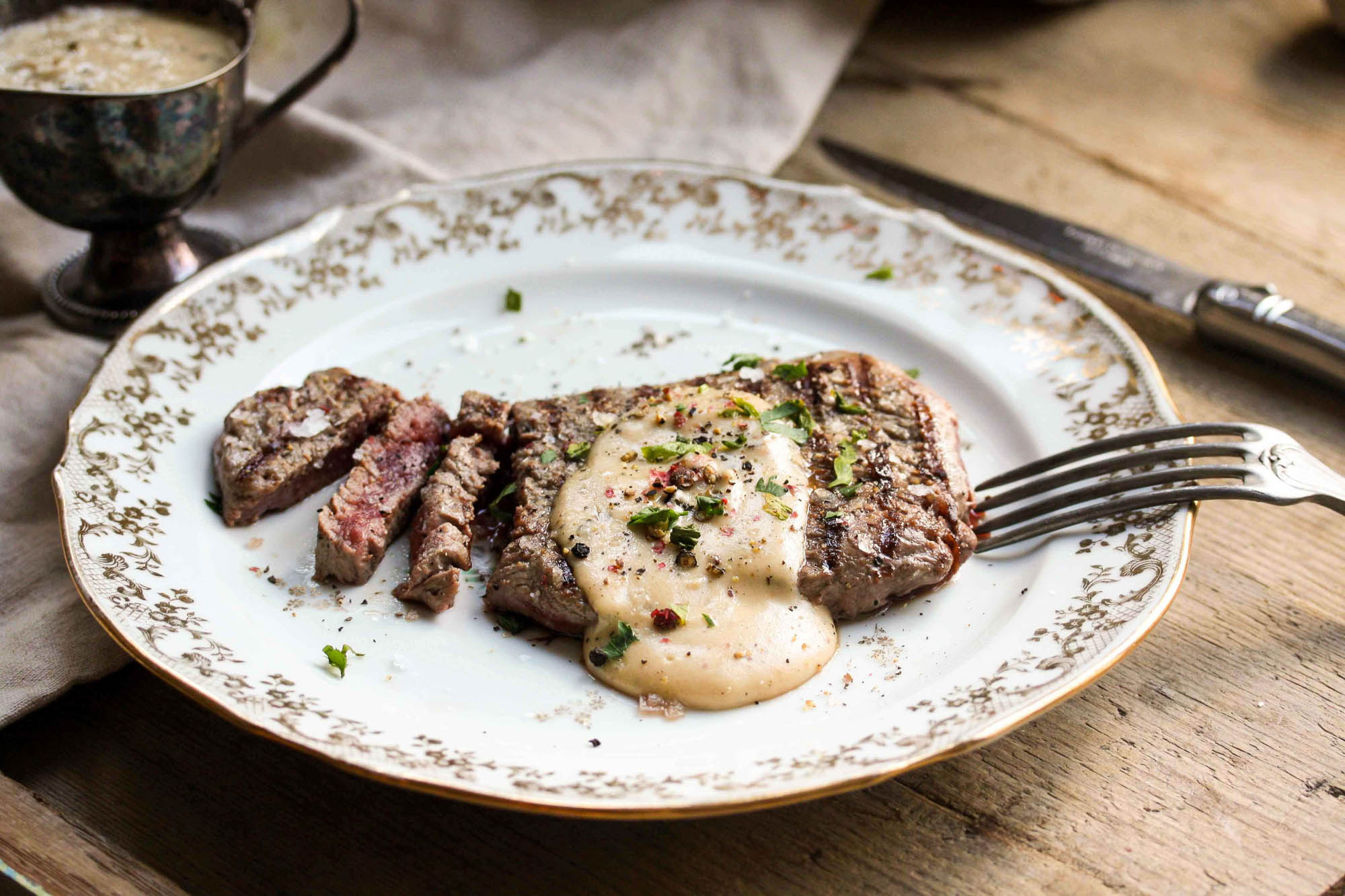 Flank Steak Rezept mit rosa gegartem Steak auf Teller mit cremiger Beilage
