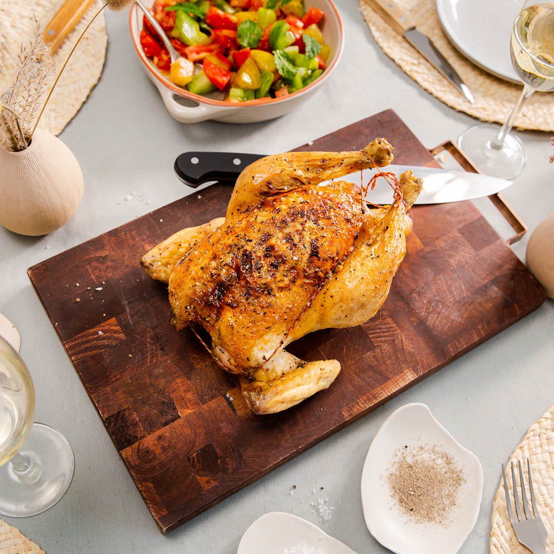 Ganzes Bio Huhn gebraten auf einem Schneidebrett