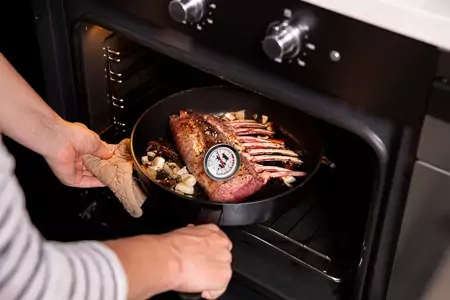 Haal de pan uit de oven, bedek het hertenrack losj