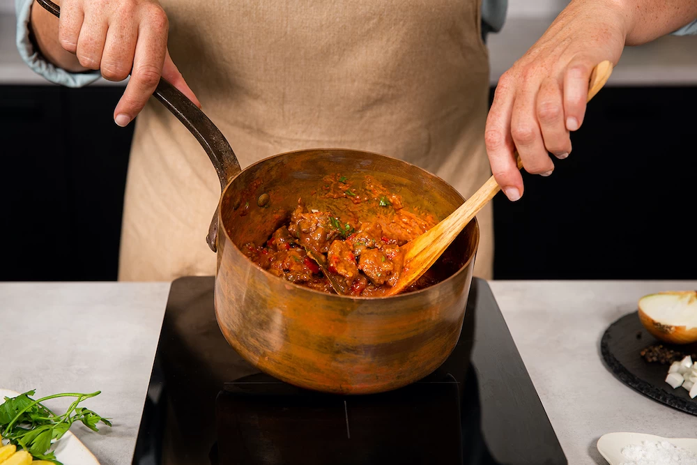Voeg de aardappelen en de wortels toe. Zet de pan 
