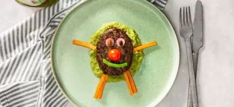 Kindermenu met hamburger, erwtenpuree en zoete aardappelfrietjes