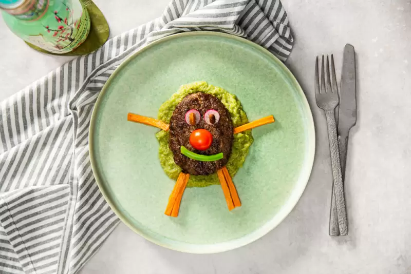 Kindermenu met hamburger, erwtenpuree en zoete aardappelfrietjes